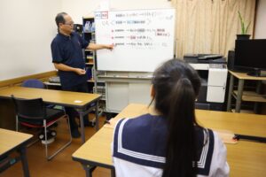 ホワイトボードで説明する先生